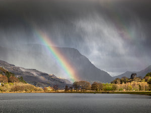 Four Seasons in One Day - Llanberis, Snowdonia - two rainbows can be seen through the storm clouds and rain above the lake of Llyn Padarn in North Wales